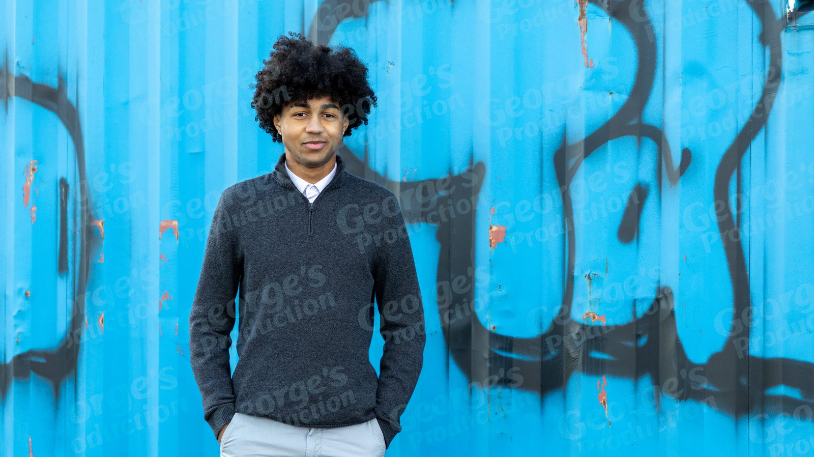 Portrait against a blue graffiti wall